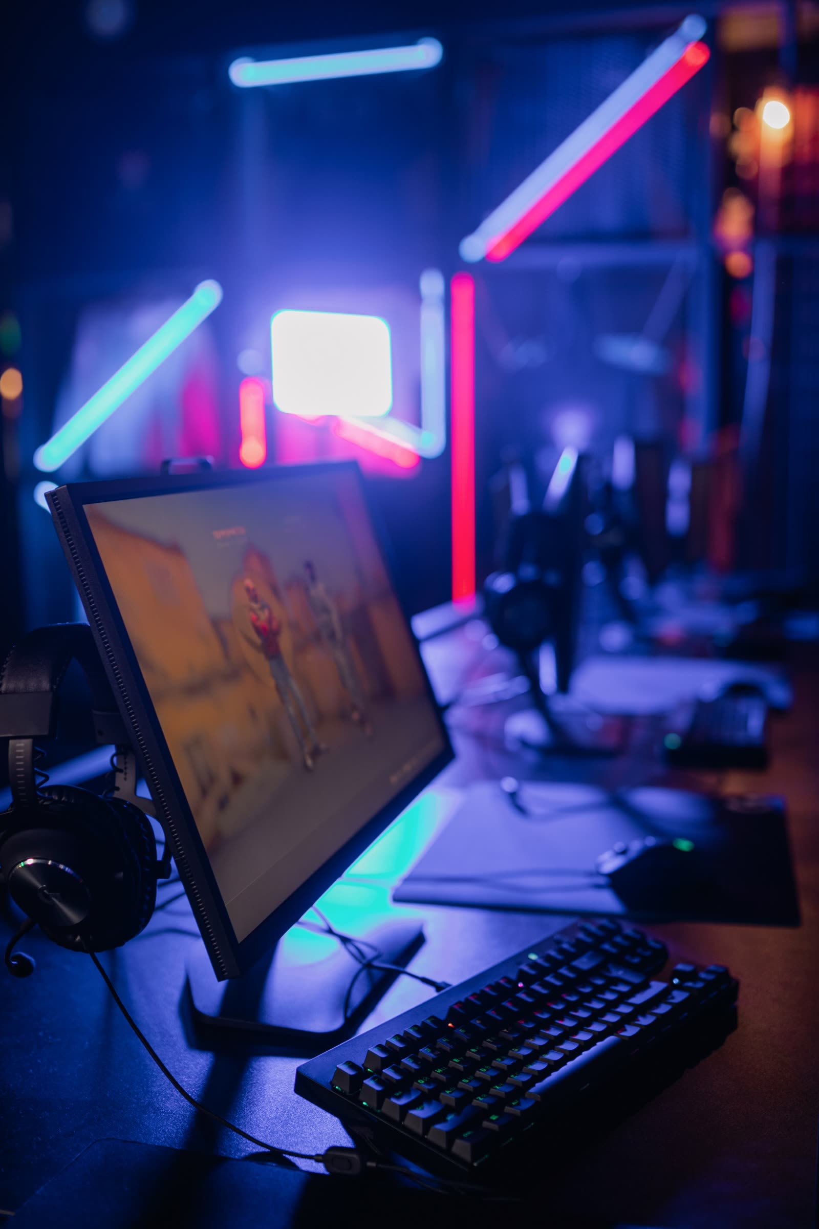 Close-up of a station: monitor, headset and a mechanical keyboard in the foreground